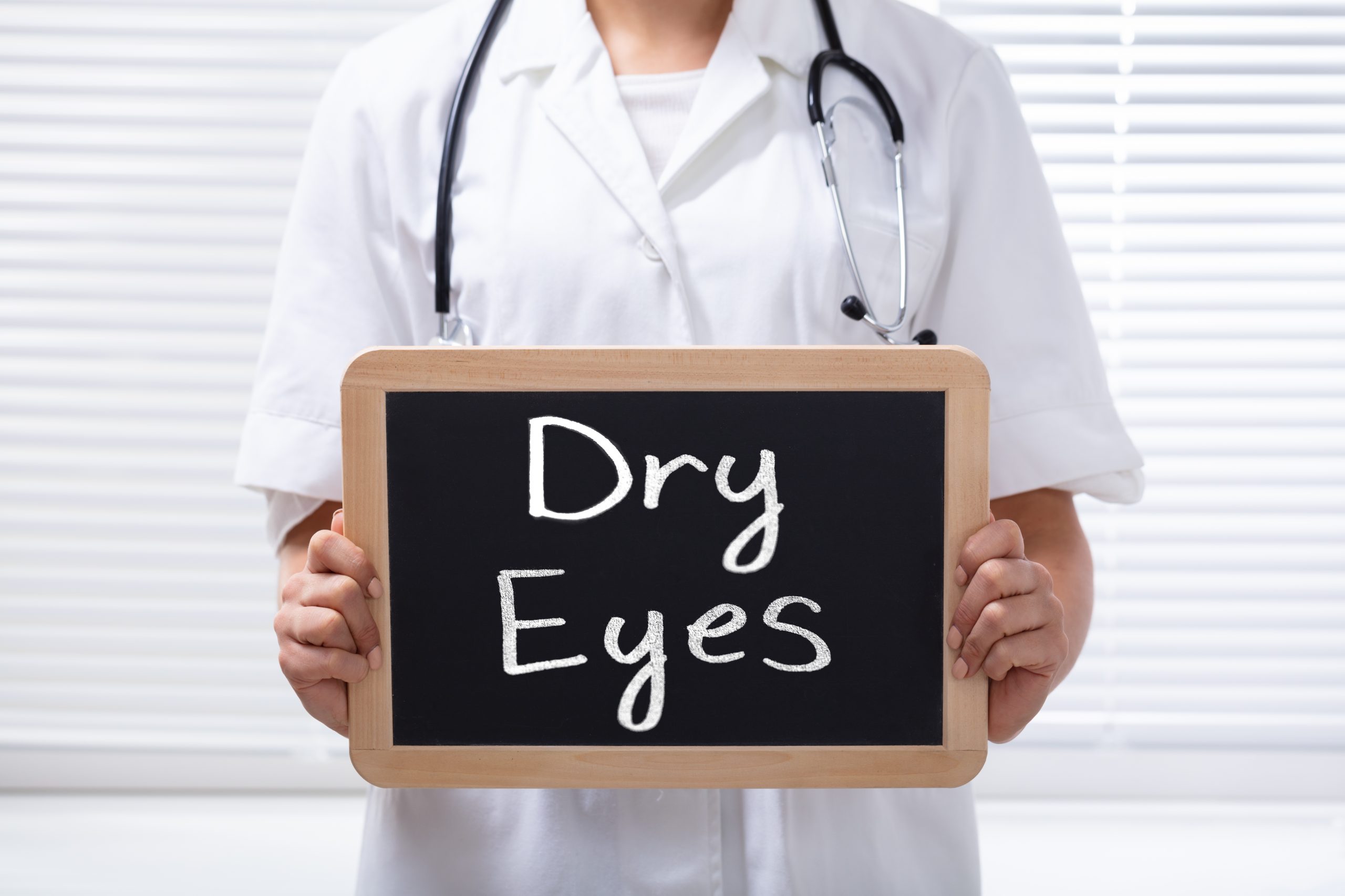 Female Doctor Holding Slate With Dry Eyes Text